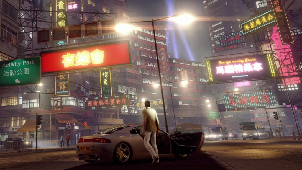 A picture of Wei Shen standing in front of a car parked in the middle of a neon-lit Hong Kong street